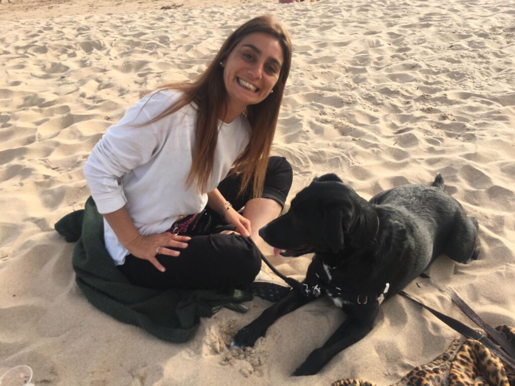 Cão de cliente satisfeita a sorrir na praia